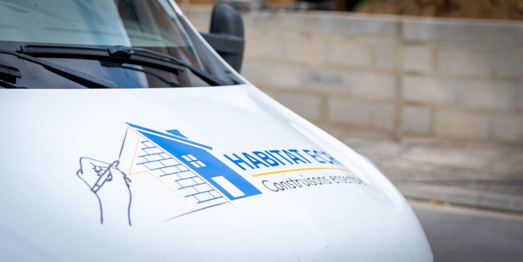 Voiture floquée Habitat ECR stationnée devant un chantier de maison dans l’Oise